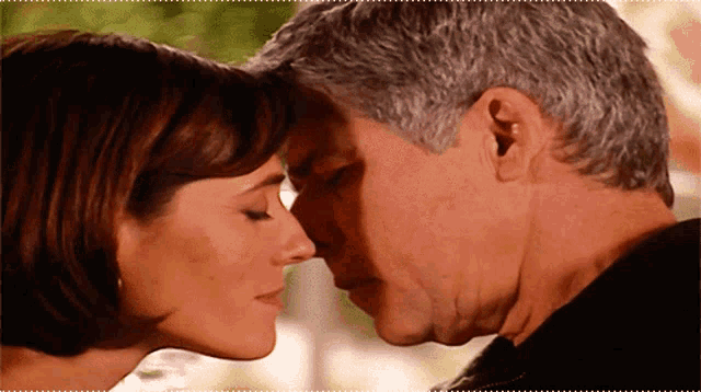 a man and a woman are touching their noses