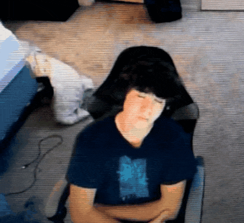a young man is sitting in a chair with his eyes closed .