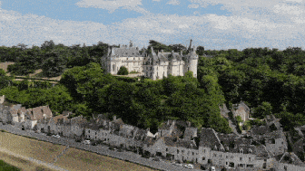 an aerial view of a castle with a row of houses in the foreground