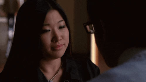 a man and a woman are looking at each other and the woman is wearing glasses