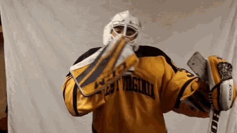 a goalie wearing a yellow jersey that says virginia