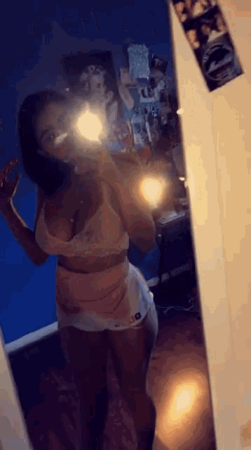 a woman taking a selfie in front of a mirror with a nike logo on her shorts
