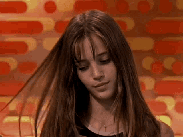 a close up of a woman 's face with her hair blowing in the wind
