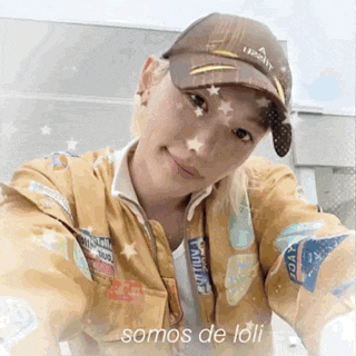 a young woman wearing a hat and a jacket is taking a selfie .