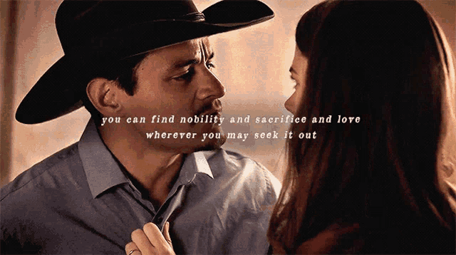 a man in a cowboy hat and a woman in a blue shirt are looking into each other 's eyes