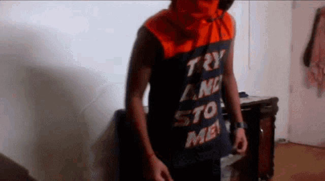 a man wearing an orange and black shirt that says try any sto me