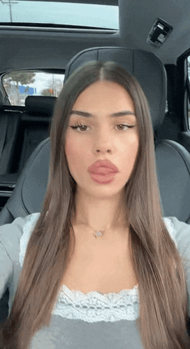 a woman is sitting in the back seat of a car with her eyes closed