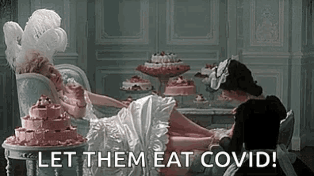 a woman in a white dress is laying on a couch next to a table with a cake on it .