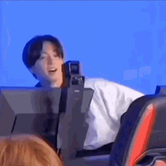 a man is sitting in a chair in front of a computer monitor .