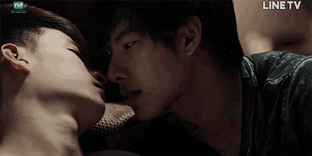 two men kissing in front of a screen that says line tv