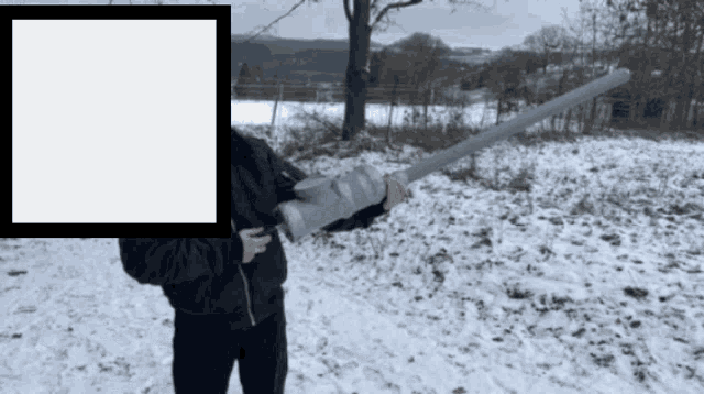 a person standing in the snow holding a large object