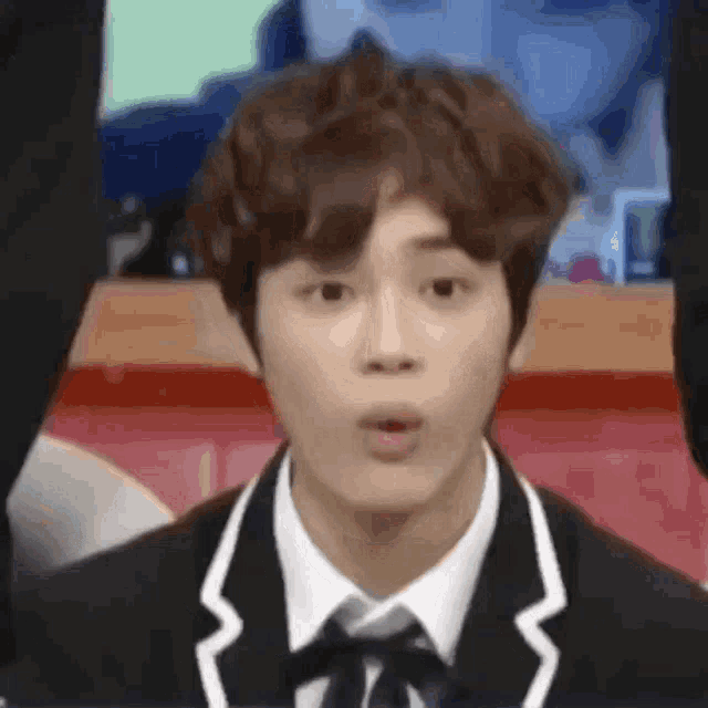 a close up of a young man in a suit and tie making a funny face .