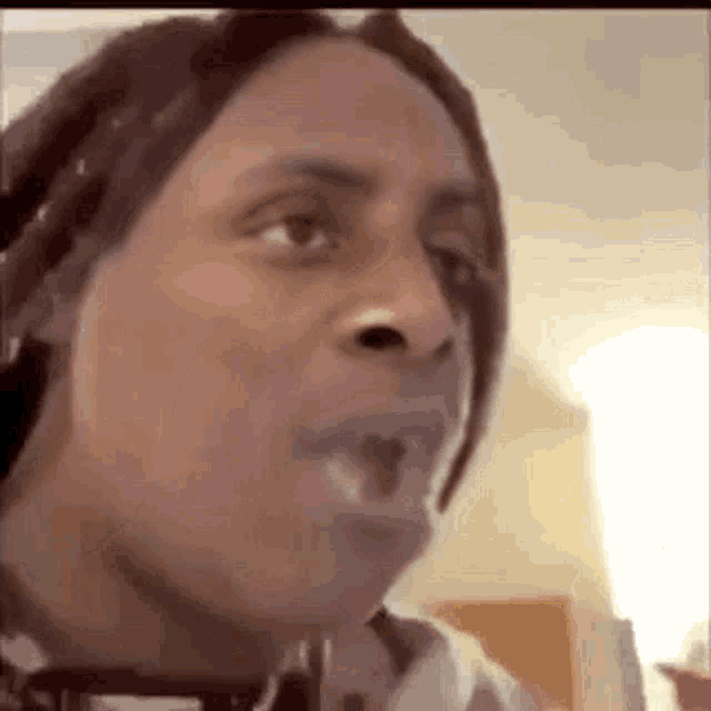 a man with dreadlocks is making a funny face while talking on a video call .
