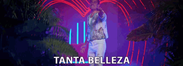 a man in a white suit is standing in front of a neon sign that says tanta belleza