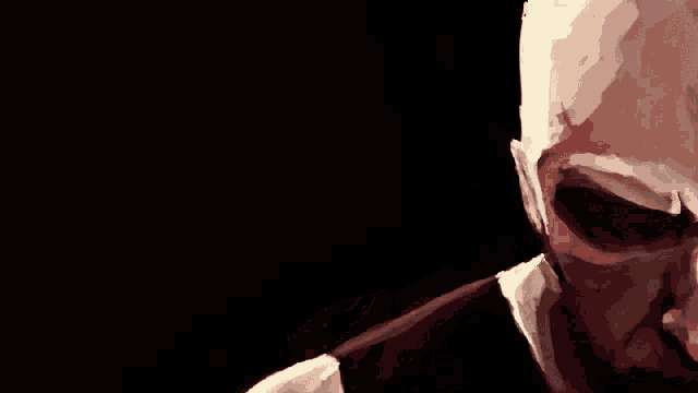 a close up of a man 's face with a dark background