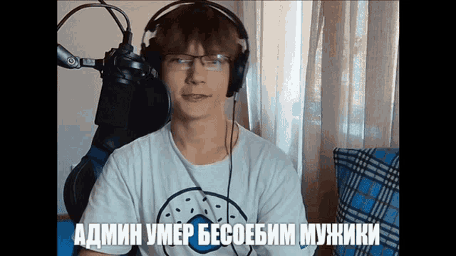 a man wearing headphones and a white shirt with a donut on it is talking into a microphone