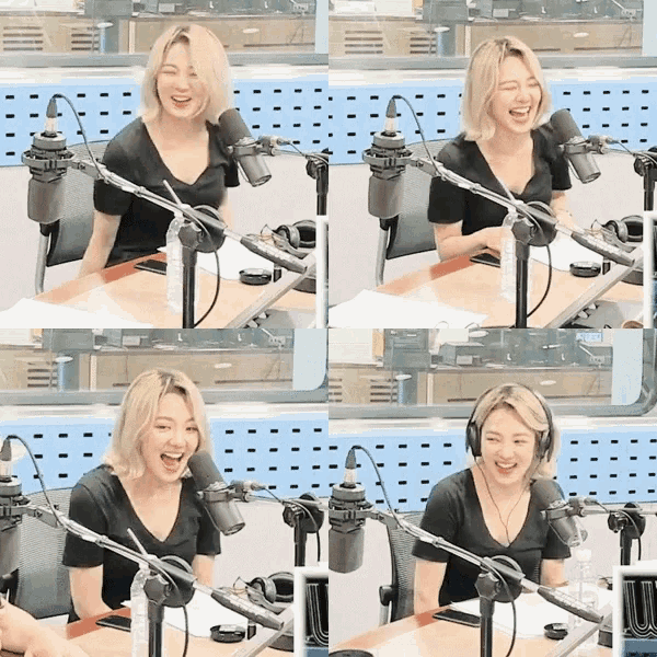 a woman laughs in front of a microphone in a radio studio