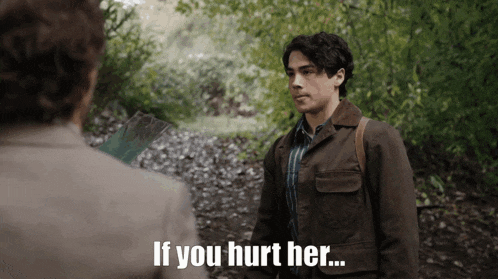 a man in a brown jacket is talking to another man with the words if you hurt her written below him