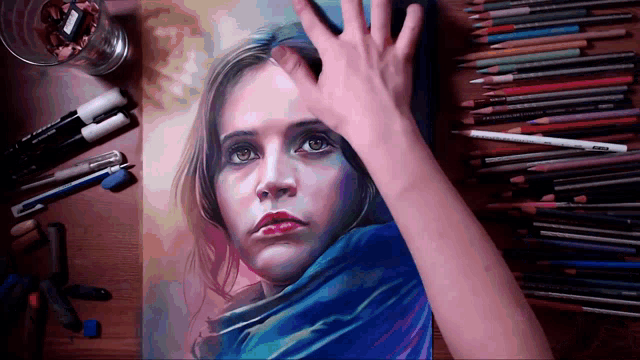 a drawing of a woman 's face is on a table surrounded by colored pencils