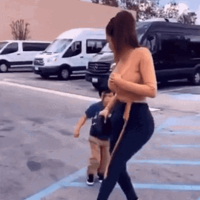 a woman holding a child in a parking lot
