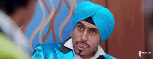a man in a blue turban is talking to another man in a blue suit .