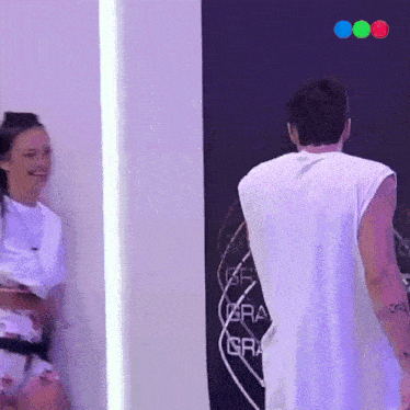a man in a white tank top is standing in front of a sign that says era gra