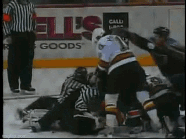 a hockey game is being played in front of an ellis 's sign