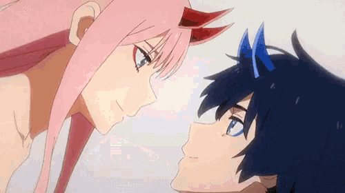 a boy and a girl are looking at each other in a close up of their faces .