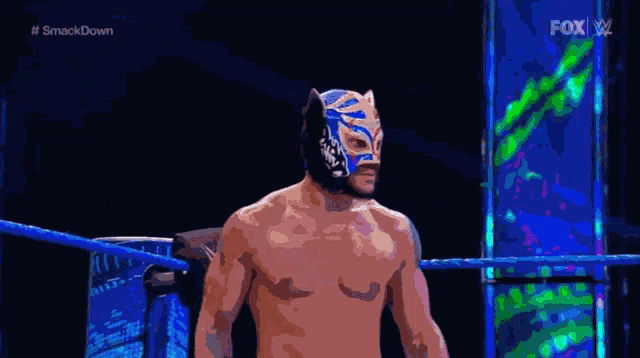 a man in a mask is standing in a wrestling ring with the words #smackdown on the bottom right
