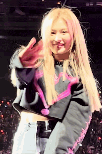 a woman wearing a black sweater with a pink heart on the front