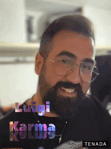 a man with a beard wearing glasses and a black shirt with luigi karma written above him