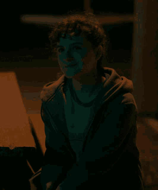 a girl with curly hair wearing a sweatshirt that says ' a & a ' on it