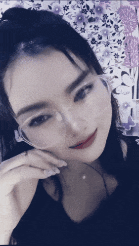 a woman wearing a pair of clear glasses is smiling