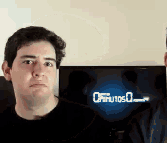 a man stands in front of a screen that says " 0 minutos "