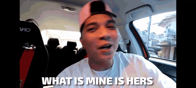 a man in a car with the words what is mine is hers on the screen