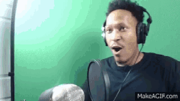 a man wearing headphones and a microphone is making a funny face .