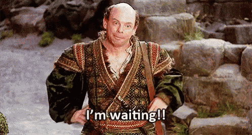 a bald man in a costume is standing on stairs and says `` i 'm waiting '' .