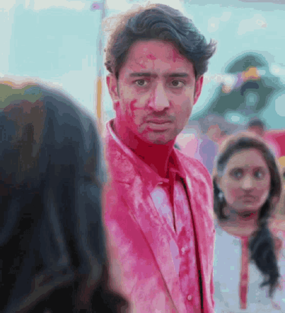 a man with red paint on his face looks at a girl