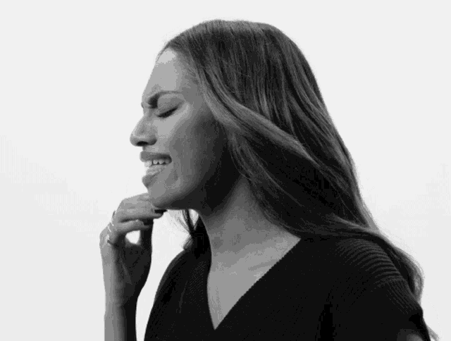 a black and white photo of a woman covering her mouth