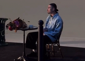 a man in a blue shirt is sitting at a table