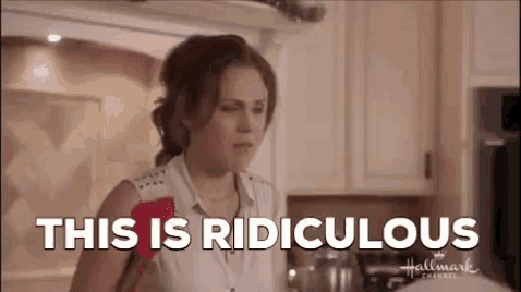 a woman is standing in a kitchen with a spatula in her hand .