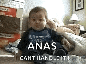 a baby is sitting on a bed wearing a blue shirt that says anas