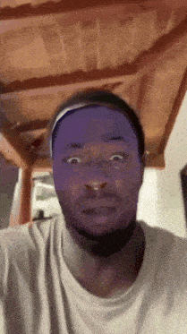 a man with a purple headband on his head is making a funny face