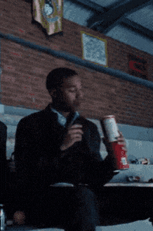 a man is holding a can of coca cola in his hand