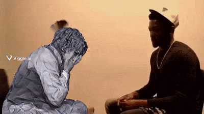 a man sitting next to a statue of a man with his head in his hands .