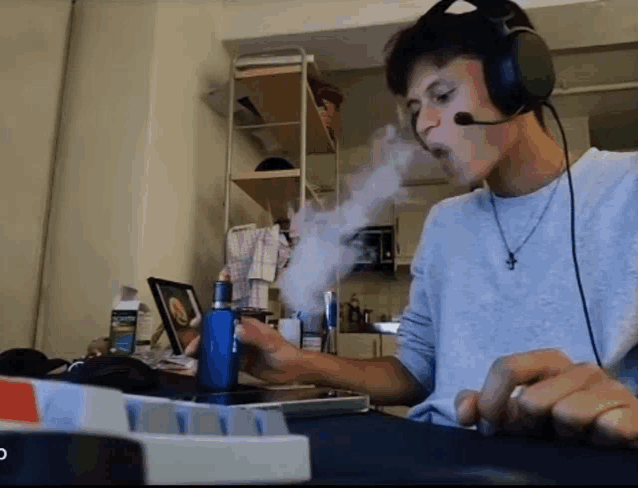 a man wearing headphones and a microphone smoking a vape
