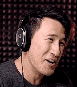 a man wearing headphones is making a funny face while talking into a microphone .