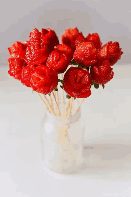 a bouquet of strawberries on sticks in a mason jar