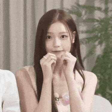 a woman with long brown hair is making a face with her hands