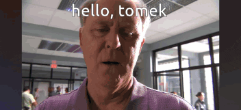 a man says hello tomek in front of a window
